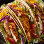 Close-up of Buffalo Chicken Tacos with vibrant toppings and a clean background.