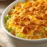 Close-up of cheesy cabbage casserole with cracker topping, showcasing a golden crust and creamy texture.