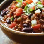 Close-up of chili in a crock pot slow cooker with beans and spices.
