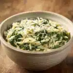 Close-up of creamy spinach orzo with parmesan, bright and appetizing.
