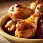 Close-up of crock pot chicken drumsticks with creamy sauce on a clean plate
