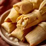 Close-up of chicken tamales with a clean background, showcasing the texture and color of the dish.