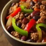Close-up of a hearty ground beef chili with beans and spices in a bowl