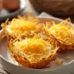 Eggs in crispy hash brown baskets with bright, natural lighting and minimal background.