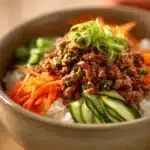 Close-up of a Korean ground beef bowl with rice and vegetables, bright and appetizing.