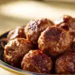 Close-up of Marry Me Meatballs with creamy sauce and herbs on a white plate