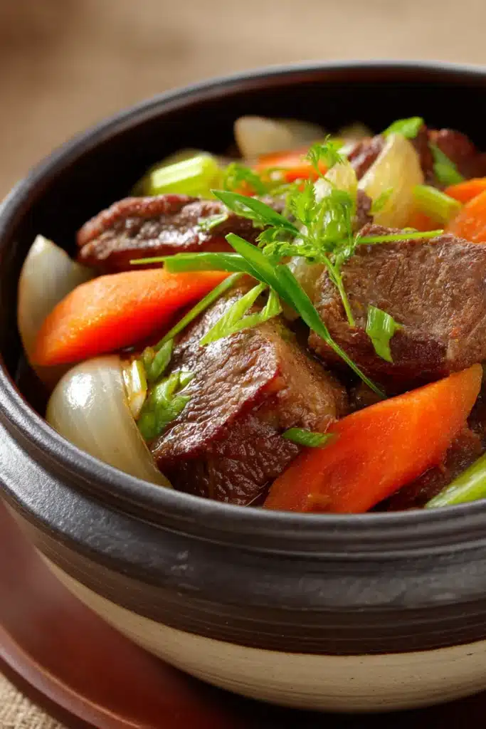 Close-up of slow cooker beef tongue with a rich, savory sauce on a white plate.