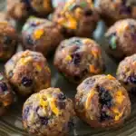 Close-up of blueberry muffin sausage balls on a white plate with a clean background.