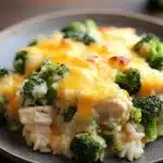 Close-up of cheesy chicken and broccoli casserole in a crock pot with melted cheese and broccoli florets.