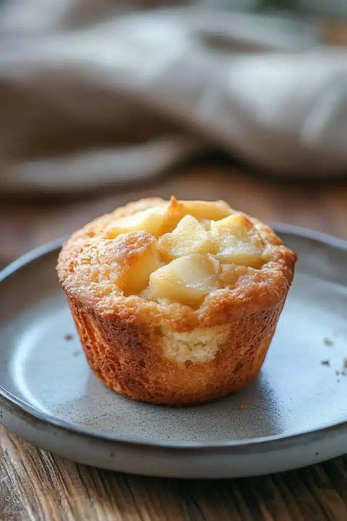 Close-up of gluten free apple muffins with a golden crust on a clean background.