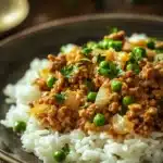 Close-up of a savory ground turkey and rice dish with herbs on a white plate