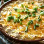 Close-up of a creamy chicken dip with herbs in a white bowl