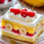 Close-up of a jello banana split cake with layers of cream and fruit