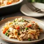 Close-up of a low calorie chicken noodle casserole with golden crust and herbs.