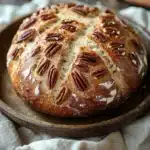 Close-up of maple pecan no knead bread with a golden crust and pecan topping
