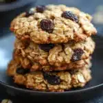 Close-up of oatmeal raisin cookies in a glass jar with a clean background