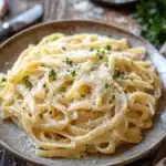 Close-up of creamy garlic cheese pasta with a sprinkle of herbs