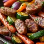 Close-up of sheet pan vegetables and sausage with vibrant colors and a clean background.