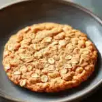 Close-up of thin and crispy oatmeal cookies on a light background