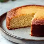 Close-up of a vanilla cake with no frosting, showcasing its texture and golden color.