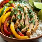Close-up of sheet pan chicken fajitas rice bowls with vibrant vegetables and grilled chicken.