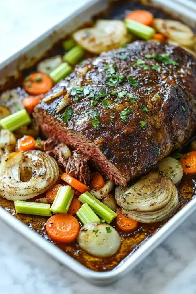 French roast beef slow cooker - the image shows a large rectangular baking dish filled with a dish of cooked meat and vegetables. the meat appears to be a roast beef, with a dark brown color and a shiny texture. it is garnished with chopped parsley on top. the vegetables in the dish include carrots, celery, and onions. the dish is sitting on a white marble countertop. the colors of the ingredients are vibrant and the dish looks appetizing.