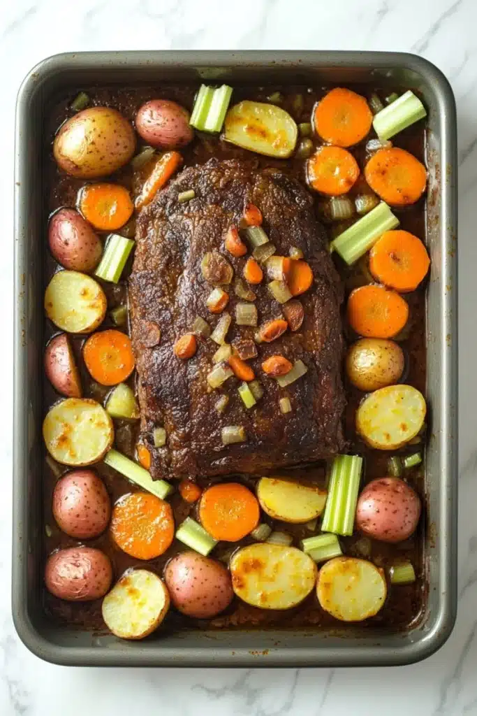 Slow cooker pot roast and vegetables - the image shows a rectangular baking dish filled with a roast beef dish. the roast beef is cooked medium-rare and is garnished with chopped carrots, celery, and onions. the dish is served in a black baking tray with a white marble countertop. there are also small potatoes and carrots scattered throughout the dish, adding a pop of color and texture. the overall appearance of the dish is savory and appetizing.